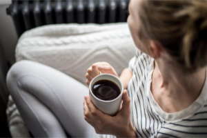 woman-enjoying-coffee-and-relaxing-on-a-sofa-gastritis-concept