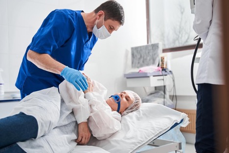 Doctor assisting a patient in a hospital during a colonoscopy exam